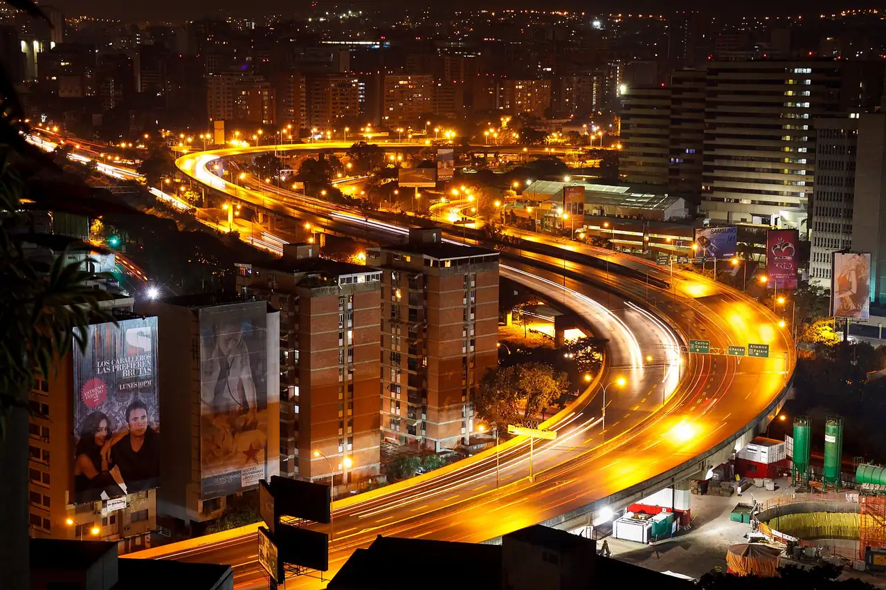 A Caracas highway at night, lit by passing cars.